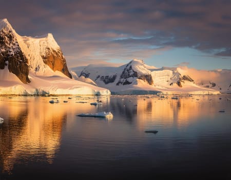 Antarctic Serenity.A breathtaking scene of snow-capped mountains reflected in the still waters of the Antarctic Ocean. The vastness of the icy landscape evokes a sense of peace and wonder.