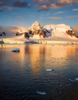 Antarctic Serenity.A breathtaking scene of snow-capped mountains reflected in the still waters of the Antarctic Ocean. The vastness of the icy landscape evokes a sense of peace and wonder.