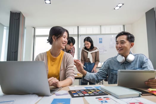 A group of professional Asian UI, UX graphic designers, or developers is in the meeting, brainstorming and planning a new project together...