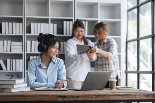 College students using laptop while sitting at table. Group study for school assignment