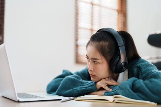 Studying online, beautiful Asian female student show symptoms burnout syndrome student studying online at home.