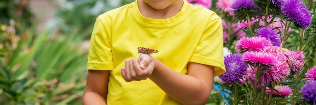 boy holding a butterfly on his hand selective focus. Nature