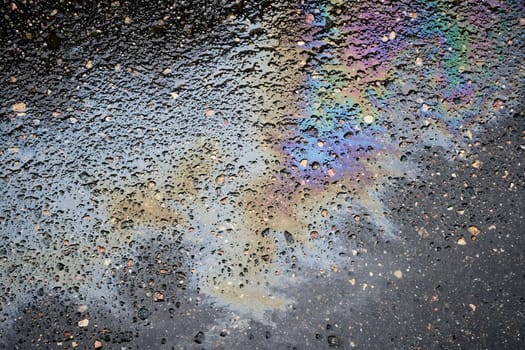 Patterns of Vibrant Oil Slicks on Rain-soaked Asphalt.