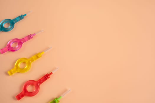 Mockup Many Colorful Interdental, Dental Brush Angle, Toothpick for Teeth Cleaning, Braces On Yellow Peach Background. Flatly Dentistry, Oral Health Hygiene. Copyspace Flossing Oral Brush, Horizontal.