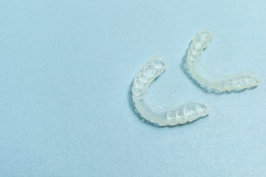 Top View Dirty Teeth Dental Night Guards in Box, White Pink Container. Blue Background. Copy Space For Text. Mockup Clear Retainer. Oral Hygiene, Cleaner. Horizontal Plane. High quality photo