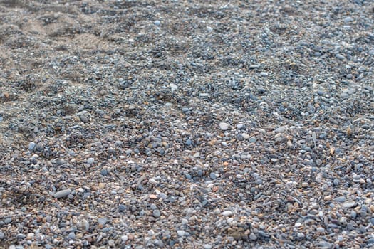 Gray small stones on sea pebble beach in Turkey, texture of stones, pebble surfaces,