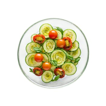 Zucchini salad with spiralized zucchini cherry tomatoes and fresh basil tossed in a pesto dressing. Food isolated on transparent background