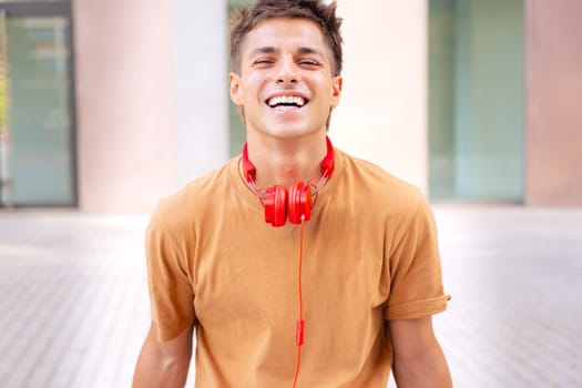 Attractive confident Caucasian teenage student looking at camera outdoors. Boy standing with happy face.