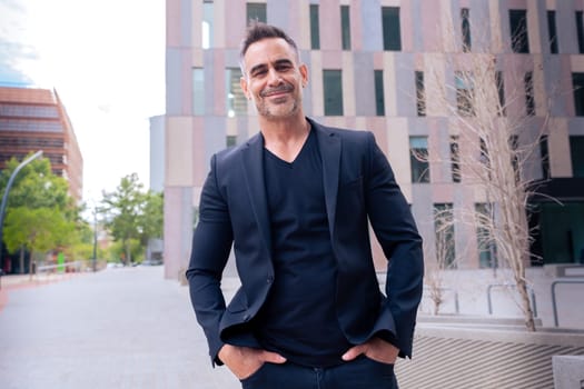 Close-up of a caucasian businessman looking smiling at the camera in a suit standing in outdoor workspace. Front view of a young lawyer with thoughtful expression staring