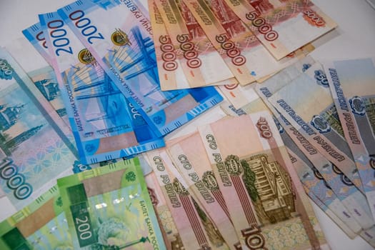 multi-colored pile of money worth five, two, one thousand Russian rubles on the table,texture of money