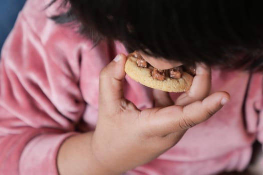child mouth eating chocolate sweet cookies .