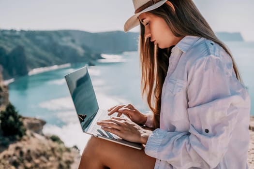 Happy girl doing yoga with laptop working at the beach. beautiful and calm business woman sitting with a laptop in a summer cafe in the lotus position meditating and relaxing. freelance girl remote work beach paradise