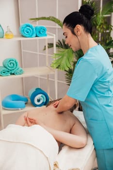 female masseur takes care of a person's back in a massage room