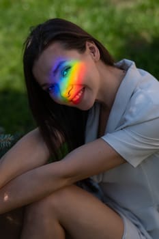 Portrait of caucasian woman with rainbow beam on her face outdoors