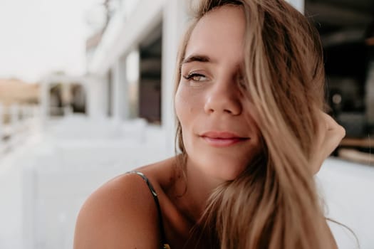 Happy woman portrait in cafe. Boho chic fashion style. Outdoor photo of young happy woman with long hair, sunny weather outdoors sitting in modern cafe