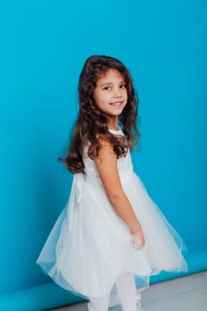 little girl in white dress on a blue background