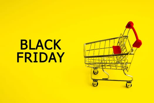 The shopping cart and the words black Friday on a yellow background. Theme of purchases and sales.