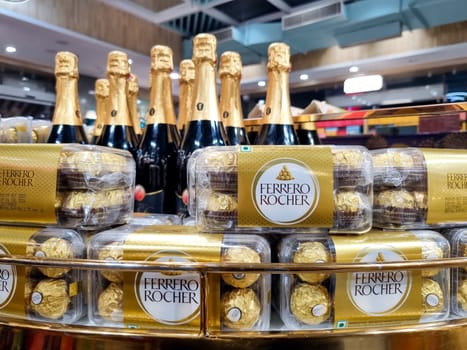 Delhi, India - 7th Dec 2023: Boxes of famous Ferrero Rocher placed on a shelf with champagne bottles showing this celebration chocolate