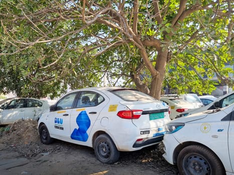 Delhi, India - 9th Mar 2024: Electric EV cars from popular ride haling online app Blusmart Blu standing in tree shade