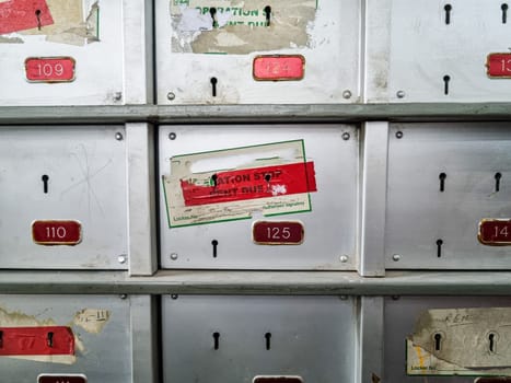 Dirty grungy bank lockers with pad locks and stickers showing non payment and foreclosure by bank