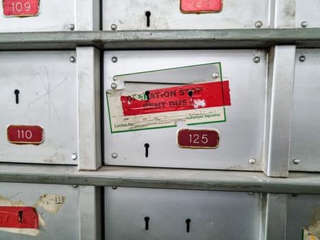Dirty grungy bank lockers with pad locks and stickers showing non payment and foreclosure by bank