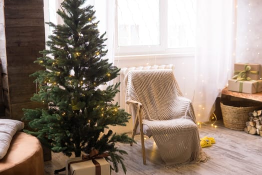 Home New Year's interior. Christmas tree with gifts, decorated with garlands. Cozy atmosphere of a home holiday, loft design of the room, Scandinavian style