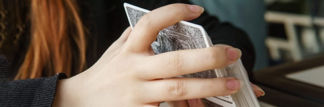 TVER, RUSSIA - FEBRUARY 11, 2023. Tarot cards, Tarot card divination, esoteric background. A woman makes a layout on the cards at the table. Divination, predictions on tarot cards