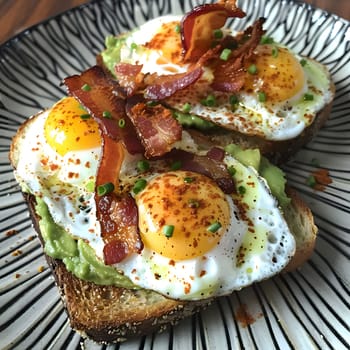 Two slices of toasted bread topped with mashed avocado, fried eggs, and crispy bacon.