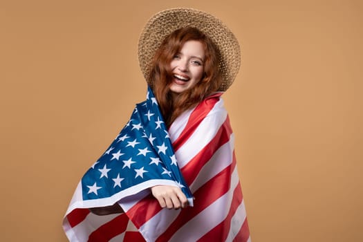 Smiling woman with national USA flag on beige background. American patriot, 4th of July - Independence day celebration, election, America, labor. US banner. High quality photo