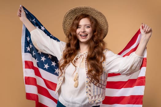 Smiling woman with national USA flag on beige background. American patriot, 4th of July - Independence day celebration, election, America, labor. US banner. High quality photo