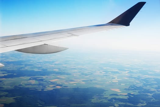 View of the green fields and clouds from within, out of the plane.