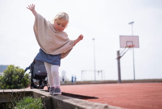 Little caucasian girl walking trying to balance