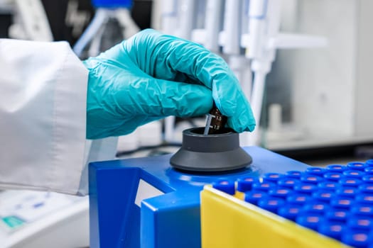 Using a vortex mixer, a chemist agitates samples before conducting HPLC analysis