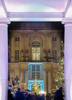 Berlin, Germany - Dec 19, 2023 - The Festive illumination of the palace facade at night. A Christmas market held in large courtyard of the restored Berlin Palace (Berliner Schloss) also known as Humboldt Forum Located on Schlossplatz. Copy space, Selective focus.