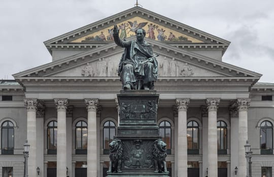 Munich, Germany - Dec 21, 2023 - Monument Bronze Statue of King Maximilian I Joseph of Bavaria in front of The National Theatre of Munich (Nationaltheater) or Bavarian State Opera (Residenztheater) at the Max Joseph Square in central Munich. Space for text, Selective focus.