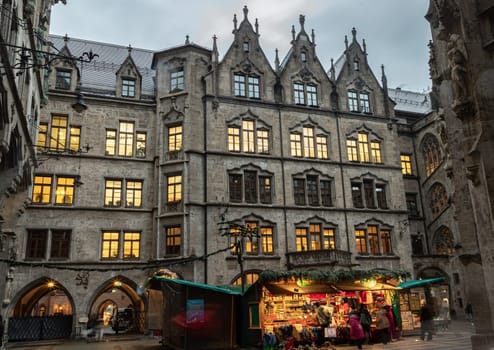Munich, Germany - Dec 21, 2023 - The Festive illumination of A Christmas market held in courtyard of New Town Hall (Neue Rathaus) on Marienplatz square at Evening. Copy space, Selective focus.