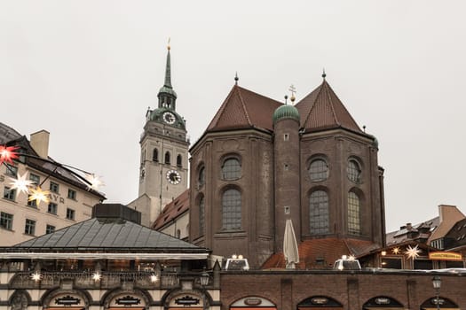 Munich, Germany - Dec 22, 2023 - Marienplatz a central square in the city centre of Munich with St. Peter's Church (Alter Peter) the oldest parish church in Munich. View from the Viktualienmarkt, Space for text, Selective focus.
