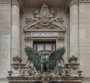 France, Paris - Jan 04, 2024 - Bronze sculpture of The imperial eagle (French Napoleonic) above entrance to The opera house Palais Garnier. Architectural details of The Palais Garnier (Opera National de Paris). Place de l'Opéra (Opera Garnier) is famous Neo-baroque building in Paris, UNESCO World Heritage Site, Copy space, Selective focus.
