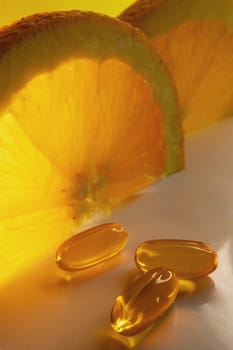 Vertical oranges background. Banner for suplements promotion. Health care concept.Essential supplements for a healthy diet.Vitamin C in soft capsules.