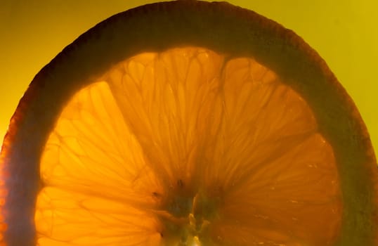 Horizontal macro picture in yellow background. Background with fresh and natural orange slice. Wallpaper for natural products, supplements and diets..