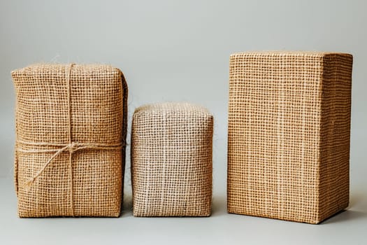 Three burlap-wrapped boxes of varying sizes, showcasing sustainable and eco-friendly packaging solutions. Responsible consumption, eco friendly packaging, zero waste concept.