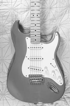 Body of a Stratocaster Guitar with a Maple fretboard, laying down. In black and white.