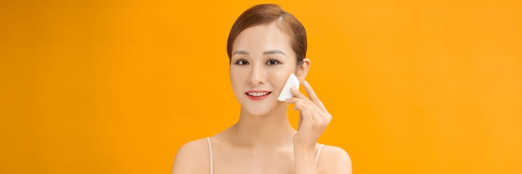 Woman Using Cotton Pad Cleansing Face Over banner yellow Background