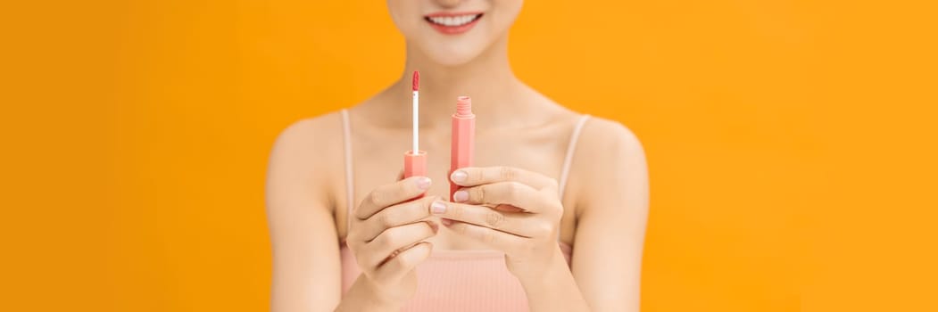 Web banner of young woman applies lipstick on lips. 