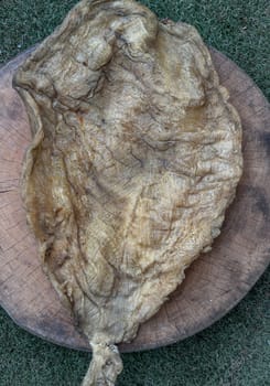 Detail of Fish Maw Soup or Dried Fish Stomach (Dried Fish Bladder) on Old wooden cutting board. Chinese dried food, Healthy eating lifestyle concept, Top view, Selective focus.