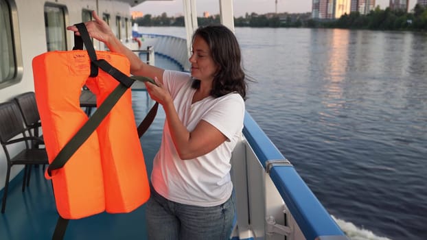 Russia, St. Petersburg , July 26 , 2024 - woman demonstrates life jacket use on a riverboat cruise.