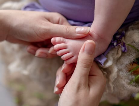 Mom'S Hands Gently Stroke The Tiny Legs Of The Newborn Baby