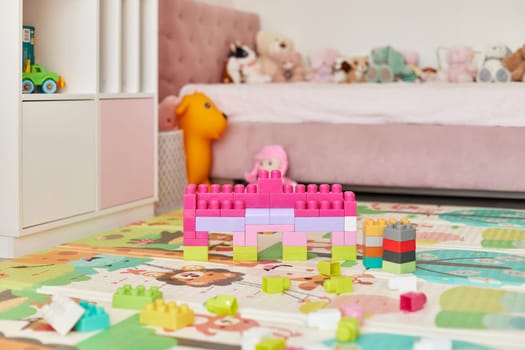 tower made with colorful toy blocks in cute baby girl room