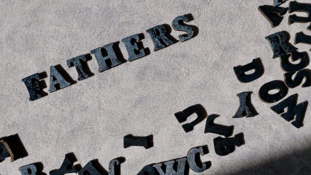 Lettering father in black letters on grey background on father's day close-up
