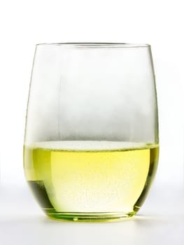 Modern stemless Chardonnay glass, short cylindrical tumbler, filled with buttery yellow-green wine, condensation droplets, side view, soft shadows, minimalist composition, pure white background.